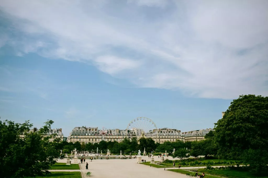 Tree‑lined path and statues in a Paris garden under clear September skies